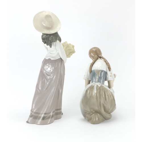 2076 - Two figurines comprising a Lladro girl with flowers and Nao girl holding wheat, the largest 39cm hig... 