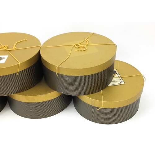 38 - Five gold and black hat boxes, one with Mary Rhodes label, each 50cm in diameter