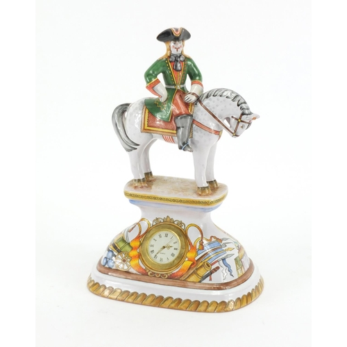 2293 - Continental porcelain desk clock, modelled with a figure on horseback, decorated with buildings, can... 