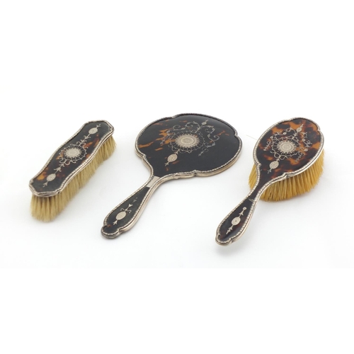 2481 - Silver and tortoiseshell Piqué work three piece dressing table set, comprising hand mirror and two b... 