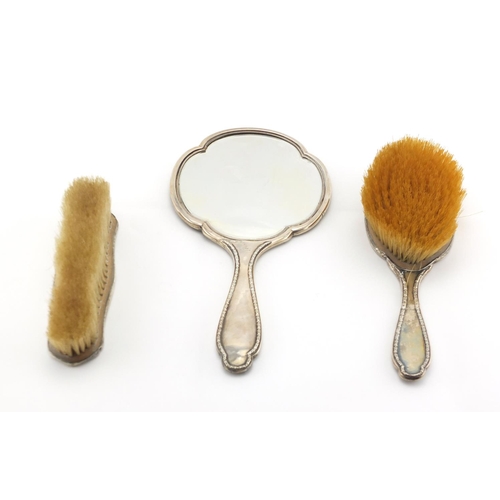 2481 - Silver and tortoiseshell Piqué work three piece dressing table set, comprising hand mirror and two b... 