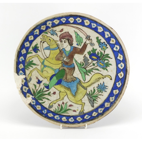 2258 - Circular Iznik pottery tile hand painted with a warrior on horseback, 37cm in diameter