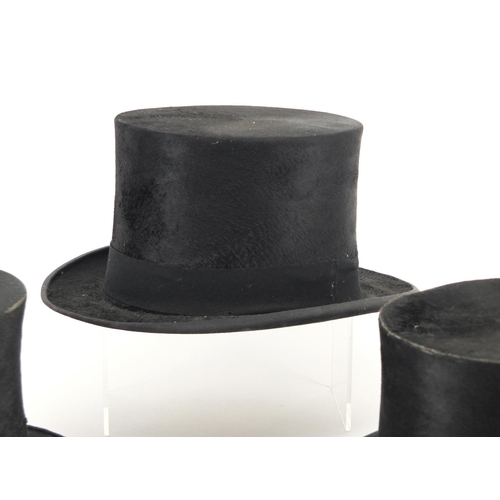 2439A - Four top hats comprising examples by Lock & Co, Dunn & Co and Henry Heath Limited, on with box