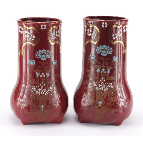 2213 - Pair of Art Nouveau pottery four footed vases, each enamelled and gilded with stylised flowers, fact... 