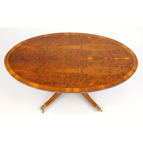 102 - Yew oval coffee table, with  brass paw feet, 51cm H x 121cm W x 69cm D