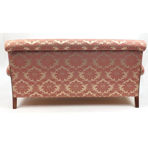 16 - Pink floral upholstered three seater settee and two matching armchairs, the settee 180cm wide