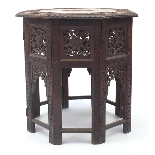 33 - Indian hardwood octagonal folding table profusely carved and pierced with flowers, 56.5cm high x 55c... 