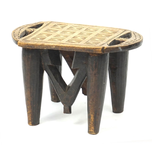 33 - Tribal carved wooden four legged stool, 25cm H x 40cm W x 23cm D