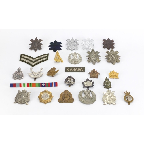 217 - Military interest cap badges and cloth patches including The Cameron Highlanders, British American a... 