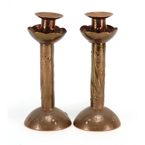 569 - Pair of Arts & Crafts copper candlesticks by Newlyn, each embossed with three stylised fish, impress... 