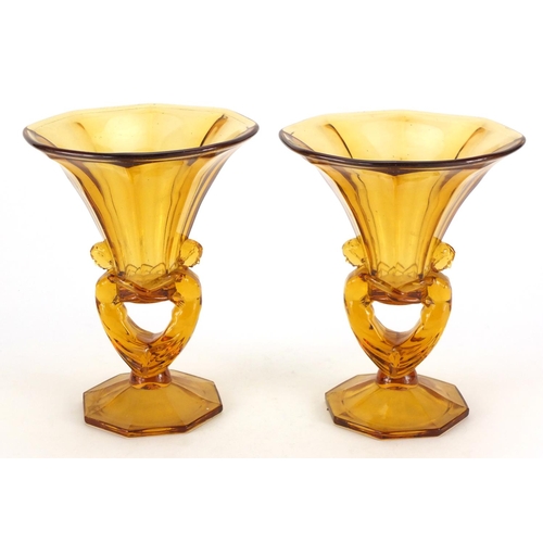 107 - Pair of Art Deco amber coloured glass vases, with figural supports, 25cm high