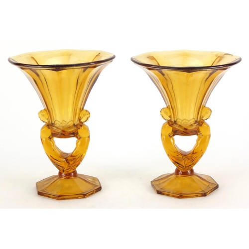 107 - Pair of Art Deco amber coloured glass vases, with figural supports, 25cm high