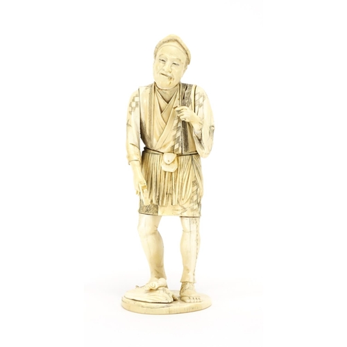 409 - Japanese carved ivory okimono of a workman, incised character marks to the base, 25.5cm high