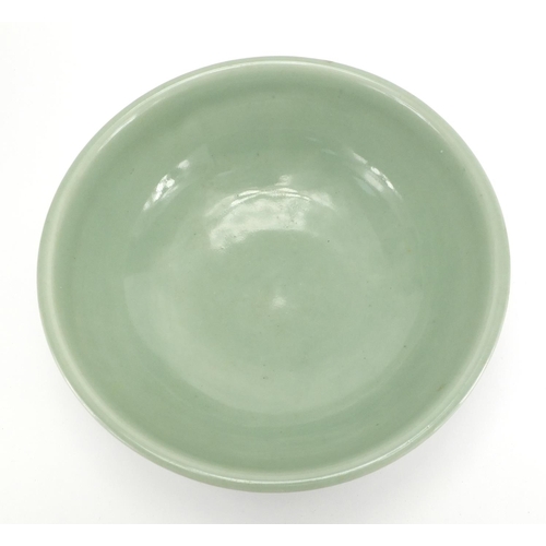 340 - Chinese celadon glazed footed bowl incised with a geometric repeat design, 26.5cm in diameter