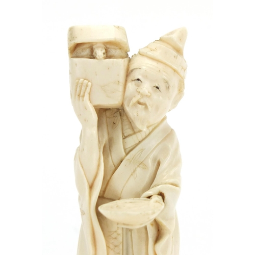 407 - Japanese carved ivory okimono of an elder holding a box, character marks to the base, 12.5cm high