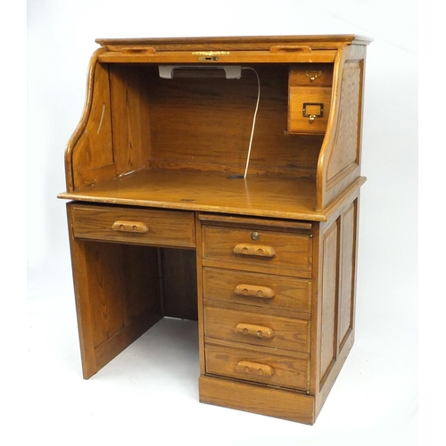 12 - Oak Tambour front desk, fitted with five drawers, 132cm H x 103cm W x 73cm D