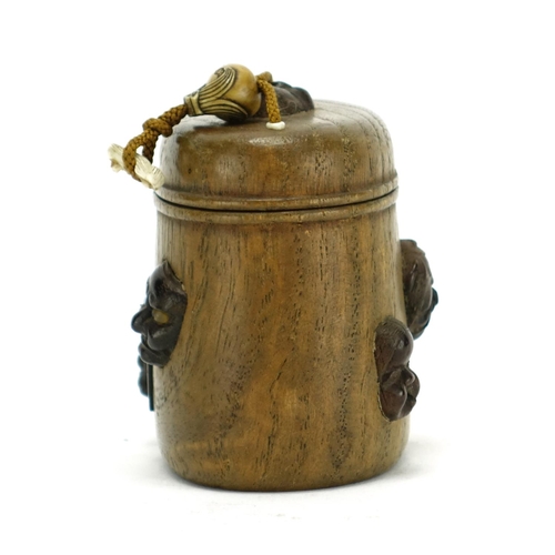 368 - Japanese oval wooden inro with carved ivory Ojime, the inro having applied Noh masks, 8cm high