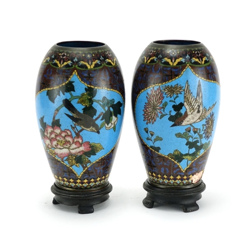 374 - Pair of Japanese cloisonné vases raised on hardwood stands, each enamelled with birds of paradise an... 