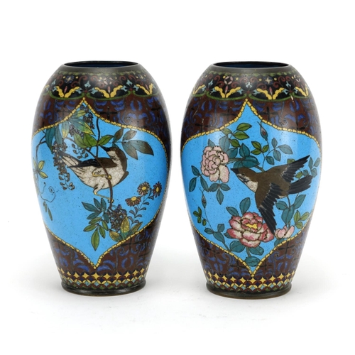 374 - Pair of Japanese cloisonné vases raised on hardwood stands, each enamelled with birds of paradise an... 