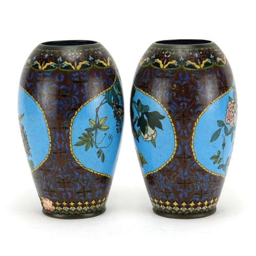 374 - Pair of Japanese cloisonné vases raised on hardwood stands, each enamelled with birds of paradise an... 