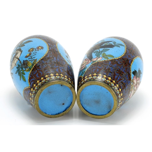 374 - Pair of Japanese cloisonné vases raised on hardwood stands, each enamelled with birds of paradise an... 