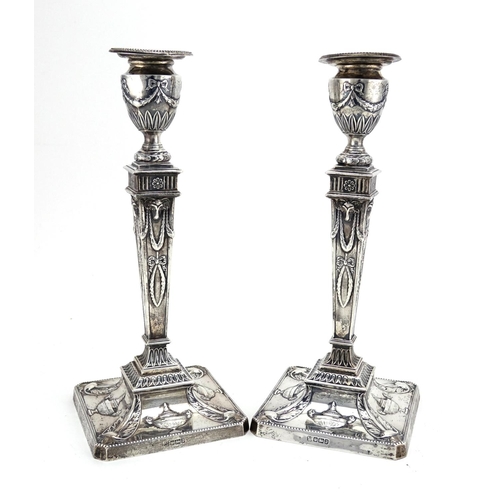 602 - Pair of Adam's style square based candlesticks with tapering columns, embossed with swags and rams h... 