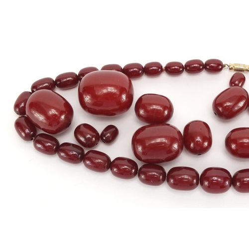 810 - Cherry amber coloured bead necklace and loose graduated beads, approximate weight 93.0g