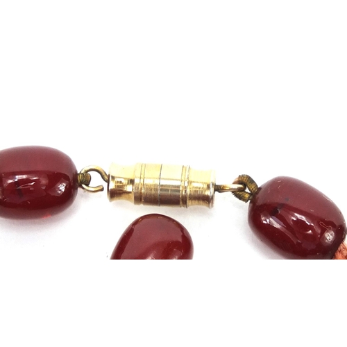 810 - Cherry amber coloured bead necklace and loose graduated beads, approximate weight 93.0g