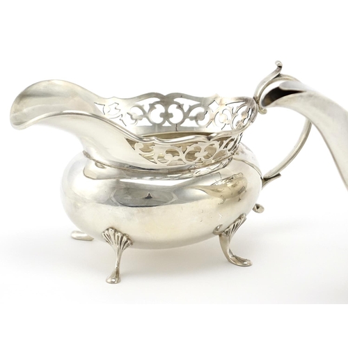 627 - Silver three piece tea service with pierced rims, by A E Poston & Co Ltd, the teapot 31cm wide, appr... 