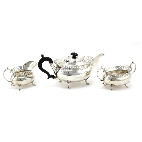 627 - Silver three piece tea service with pierced rims, by A E Poston & Co Ltd, the teapot 31cm wide, appr... 