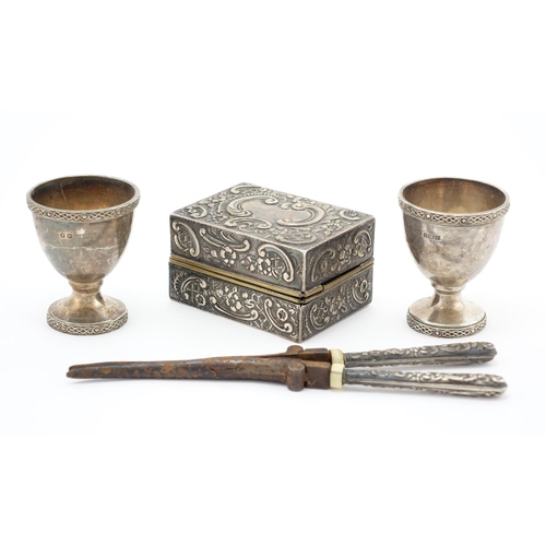 652 - Silver handled hair curlers with burners and pair of egg cups, the curlers 17cm in length, approxima... 