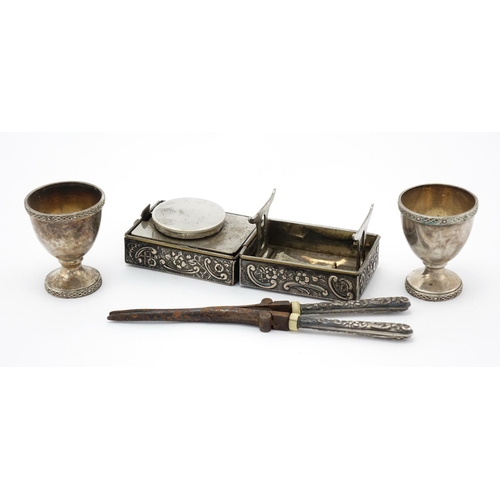 652 - Silver handled hair curlers with burners and pair of egg cups, the curlers 17cm in length, approxima... 