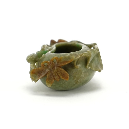 393 - Chinese green and russet jade naturalistic brush washer, carved with a bat and butterfly, 14cm wide