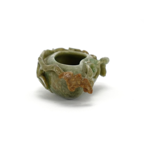 393 - Chinese green and russet jade naturalistic brush washer, carved with a bat and butterfly, 14cm wide