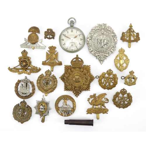 215 - Group of British Military cap badges and a Military issue Leonidas pocket watch