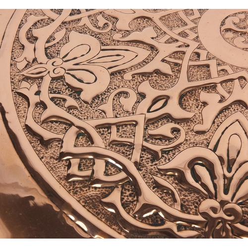 568 - Large Arts & Crafts copper charger by Keswick, embossed with stylised floral motif, impressed marks ... 