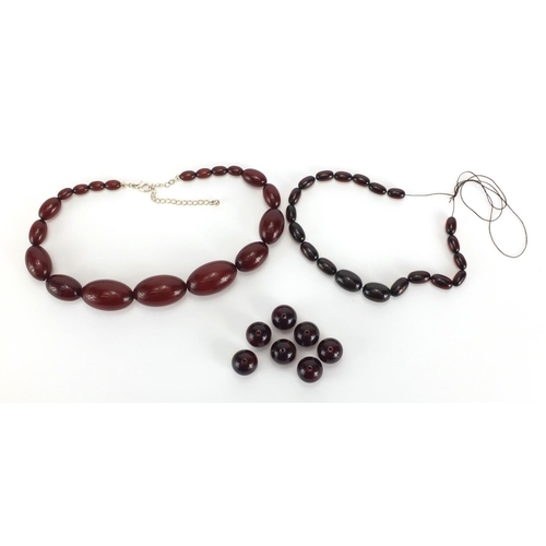 813 - Two amber coloured bead necklaces and a selection of loose beads, the largest bead approximately 3.5... 