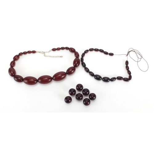 813 - Two amber coloured bead necklaces and a selection of loose beads, the largest bead approximately 3.5... 