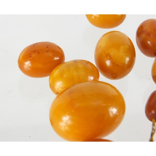 803 - Butterscotch amber coloured beads, the largest 2.5cm in length, approximate weight 68.0g