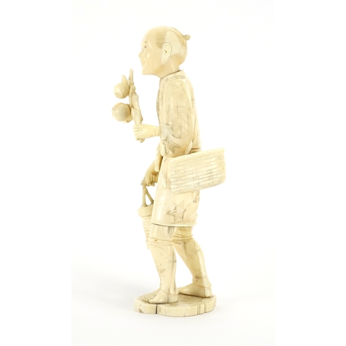 411 - Japanese carved ivory okimono of a man carrying fruit, character marks to the base, 23cm high