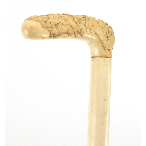 79 - Oriental hyde walking stick with ivory handle, finely carved with rabbits, 87cm in length