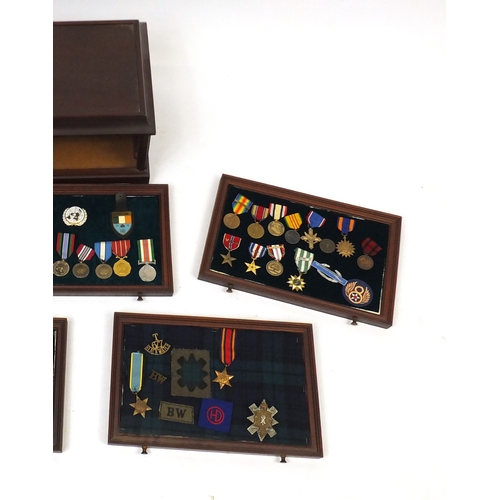 213 - Military interest medals, awards and badges arranged in a collectors chest including World War II St... 