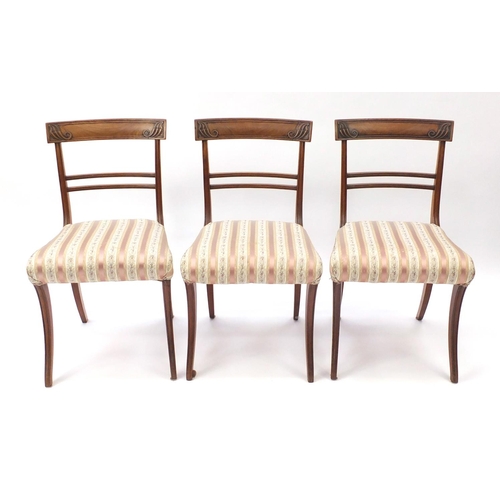 17 - Set of six Regency mahogany dining chairs, with carved top rails and striped upholstered stuff over ... 