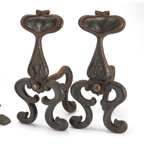 99 - Pair of Art Nouveau cast iron fire dogs with inset copper spade design plaques together with a simil... 