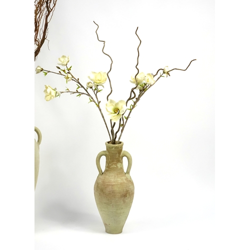 64 - Two floor standing terracotta vases, with artificial flowers, the largest vase 78cm high