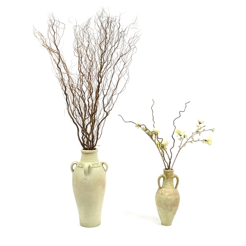 64 - Two floor standing terracotta vases, with artificial flowers, the largest vase 78cm high