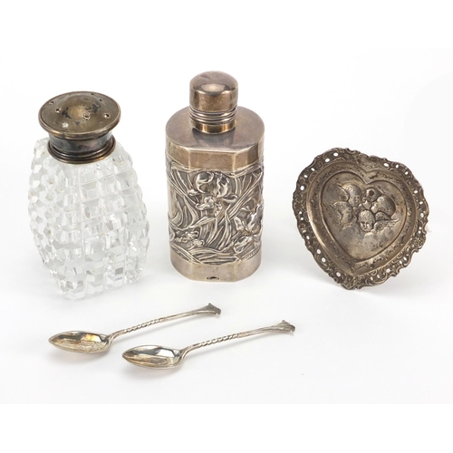 2386 - Silver objects comprising an aesthetic bottle holder, heart shaped pin dish, two teaspoons and a cut... 