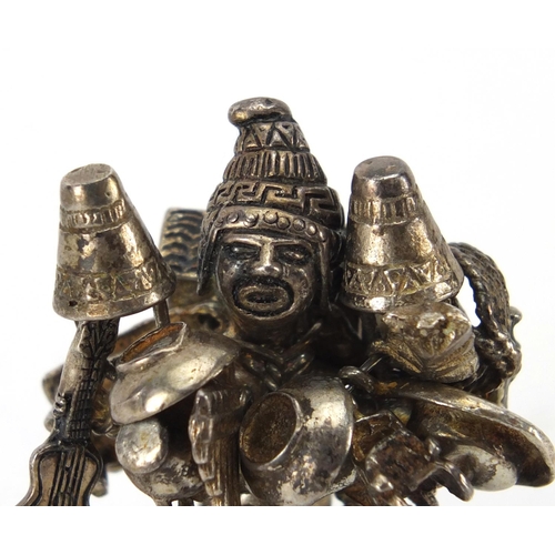 2393 - Unmarked Middle Eastern silver figure carrying objects including a guitar, aeroplane, car and cups a... 
