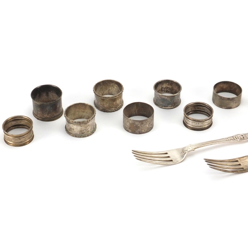 2390 - Silver items comprising three Georgian table forks, eight napkin rings and rectangular photo frame, ... 