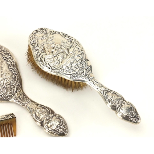 2410 - Victorian silver three piece dressing table set, including hand mirror, embossed with continental fi... 